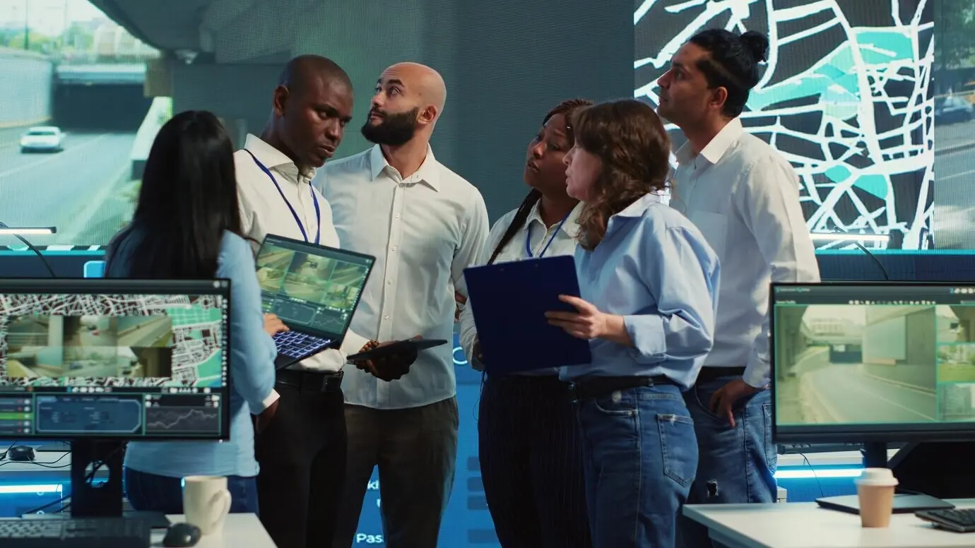 Un equipo diverso de empleados une fuerzas para guiar camiones de reparto.